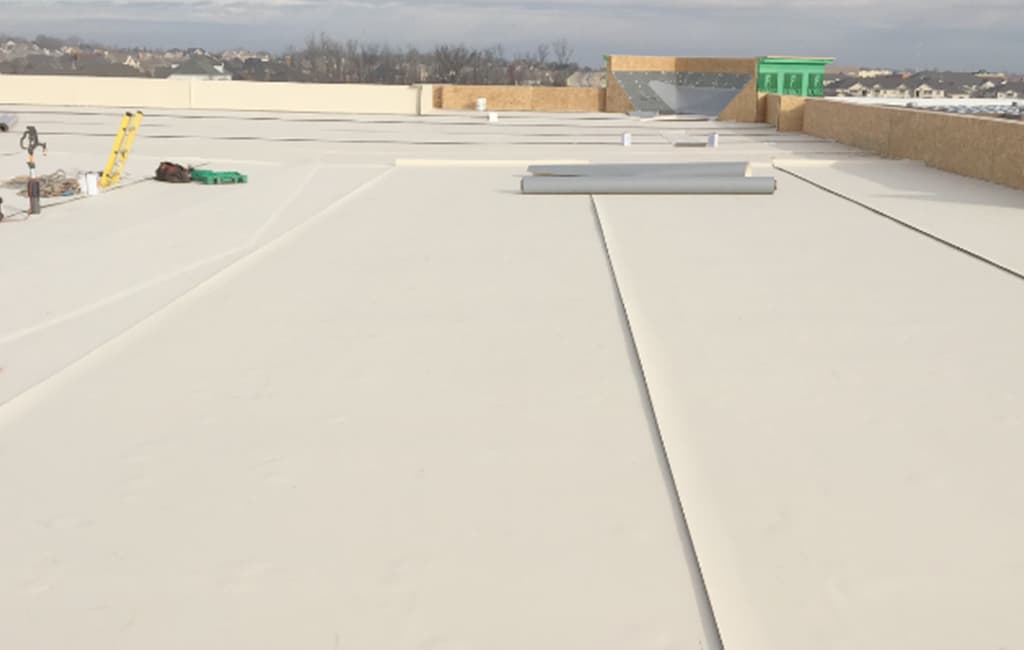 Commercial roofing technicians inspecting and repairing a flat roof